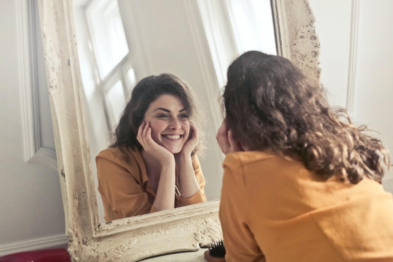 femme heureuse se regarde dans le miroir