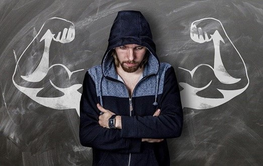Homme devant un tableau avec des muscles dessinés